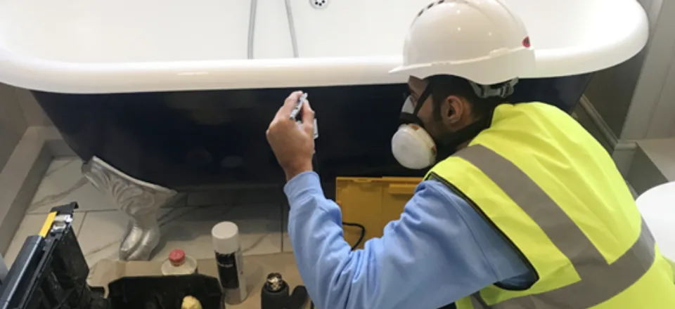 Surface Doctor technician refinishing the outside of a roll-top bath